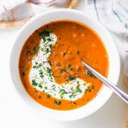 tomaten linsen suppe in schüssel mit kokosmilch und einem löffel