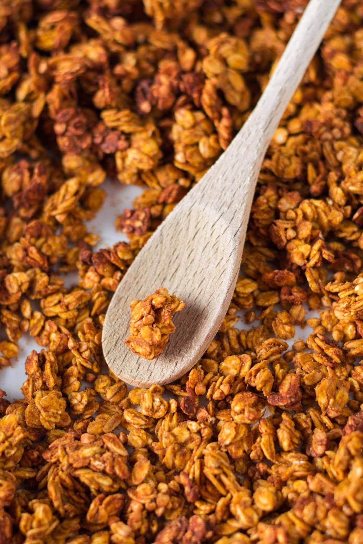 kürbis granola mit einem holzlöffel in der mitte