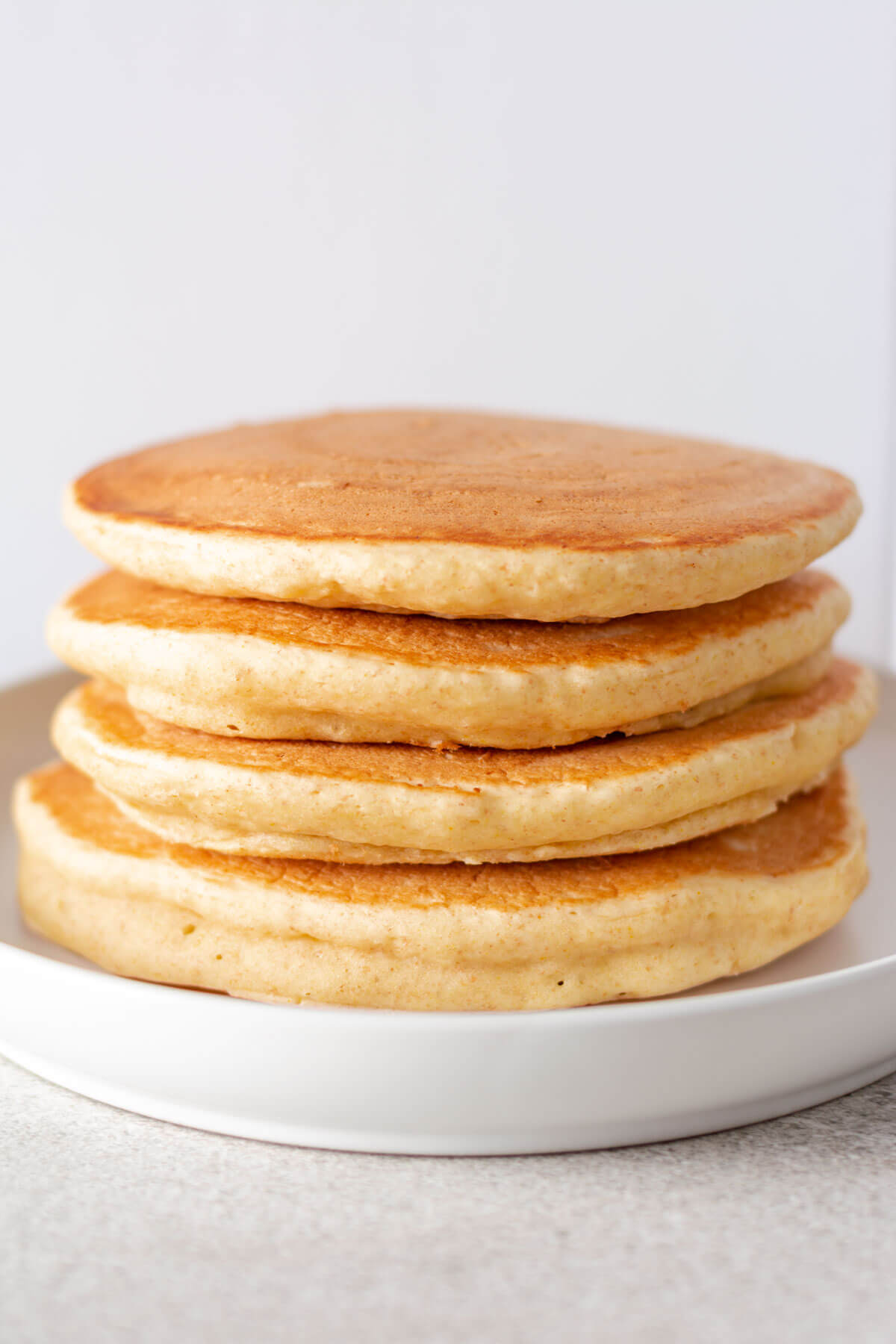 vier pancakes gestapelt auf weißem teller