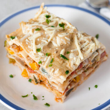 vegane lasagne mit ratatouillegemüse auf einem weißen teller.